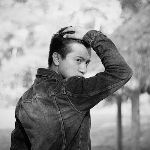 Grayscale Photo of a Man in Denim Jacket Posing