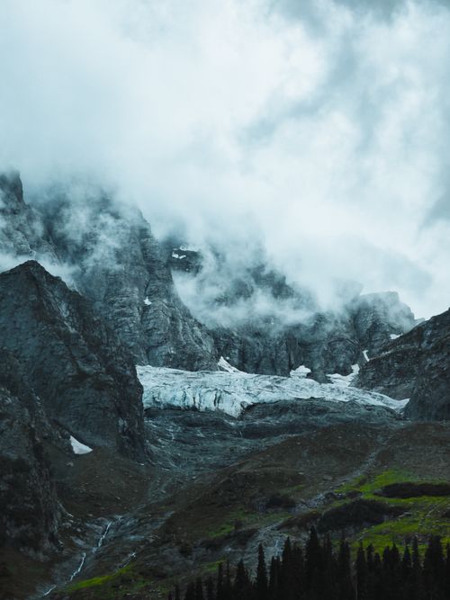 Free A stunning aerial view of rocky mountains shrouded in clouds, capturing nature's awe-inspiring beauty. Stock Photo