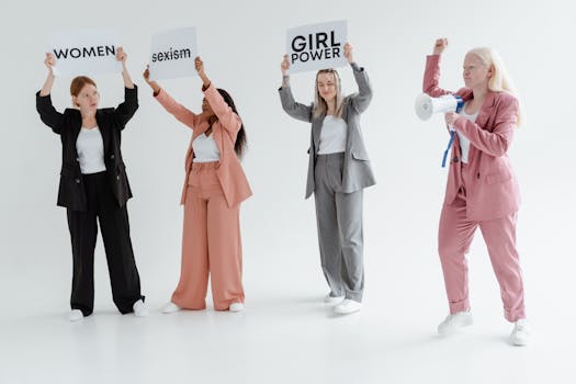 A group of women in business suits holding signs and a megaphone, promoting feminism and equality.