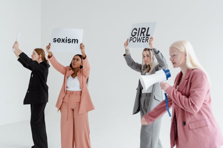 A Group Of Women Protesting While Holding Placards