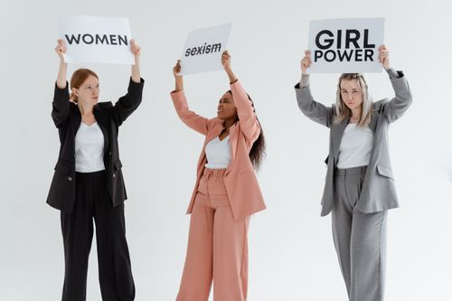 Free Three women in business attire holding signs advocating for equality and women's rights. Stock Photo