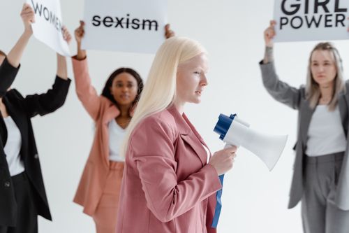 Free Women in business attire holding signs and megaphone at a protest for equality. Stock Photo