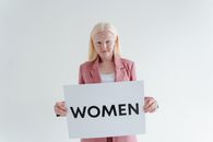 Woman in Pink Shirt Holding White I Love You Print