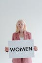 Woman in Pink Long Sleeve Shirt Holding White Box