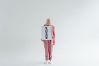 Woman in Pink Long Sleeve Dress Holding White and Black Book