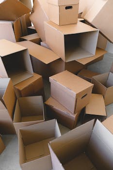 A pile of empty cardboard boxes ready for packing and moving indoors.