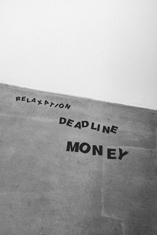 Black and white from below background of Relaxation Deadline and Money titles on gray wall