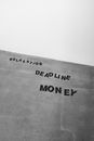 Black and white from below background of Relaxation Deadline and Money titles on gray wall