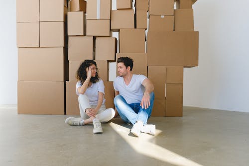 Couple speaking against pile of boxes in new house