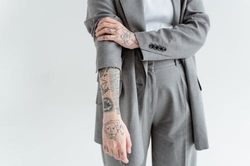 Kostnadsfri bild av arm tatuering, grå kappa, händer