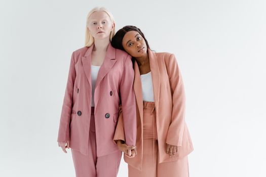 Two women in stylish blazers stand in solidarity, exemplifying unity and empowerment.