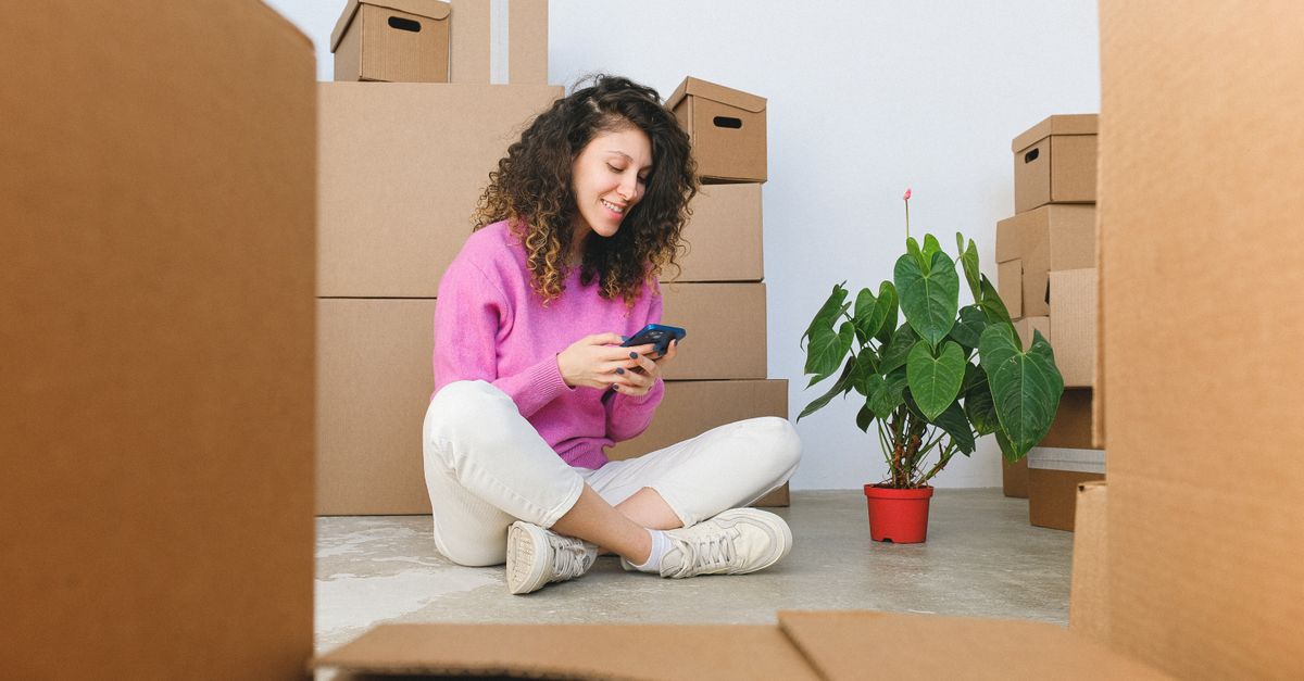 Hispanic woman on phone receiving WhatsApp mortgage approval notification in California home
