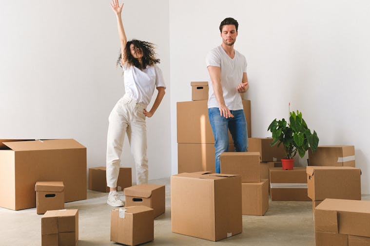 Young couple joyfully unpacking boxes in their new home.