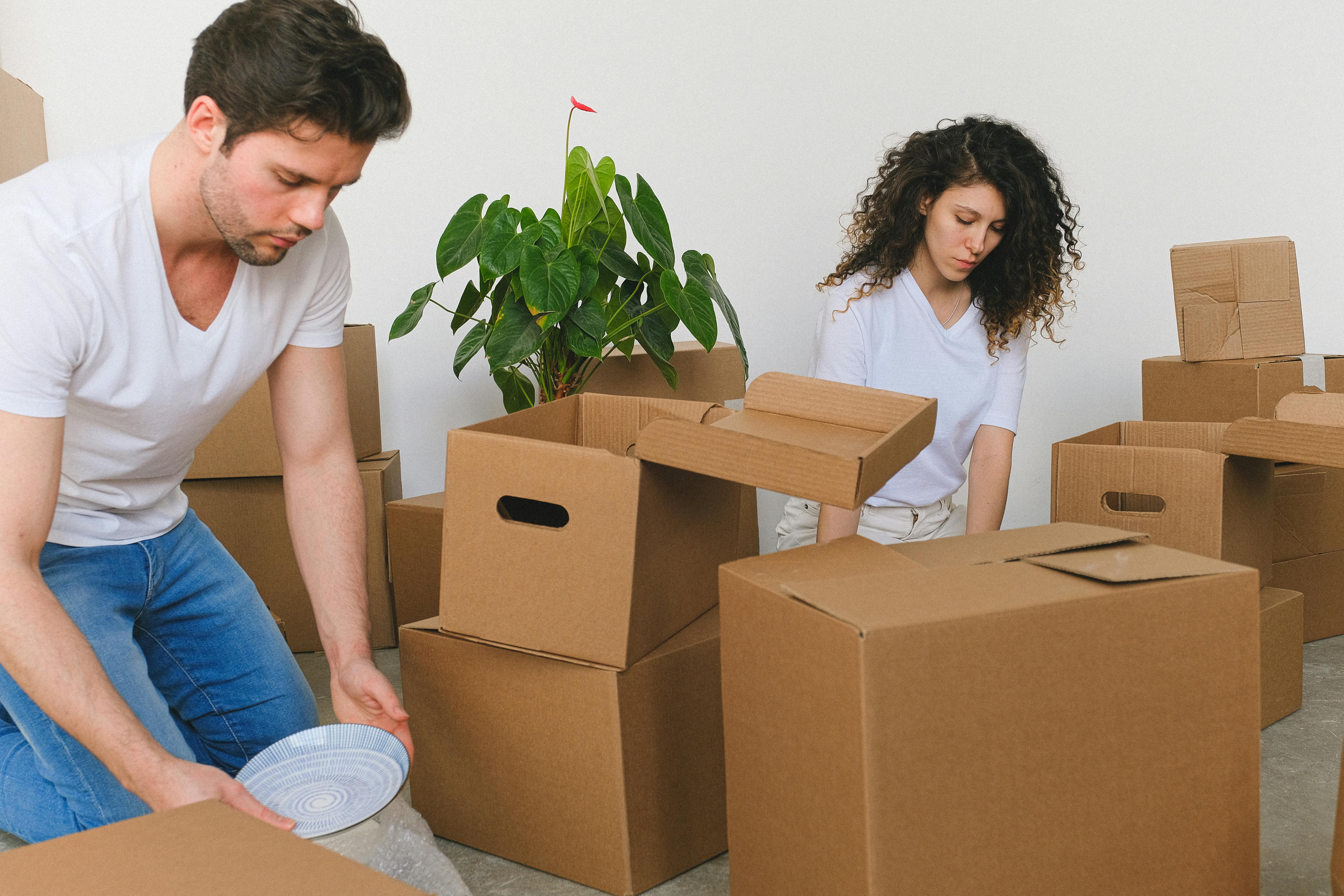 attentive young couple packing stuff while relocating in new flat