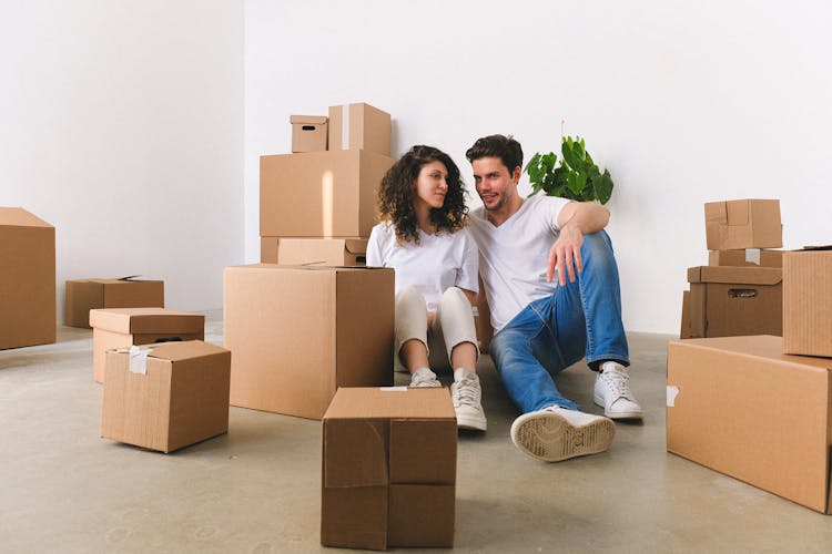 Happy Couple Among Unpacked Carton Boxes