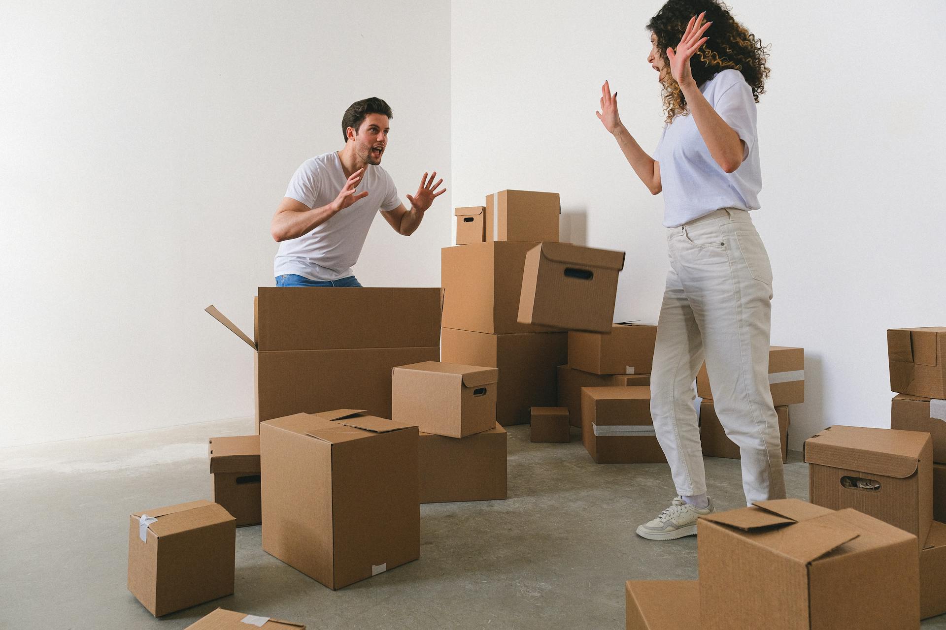 Couple unpacking carton boxes and conflicting