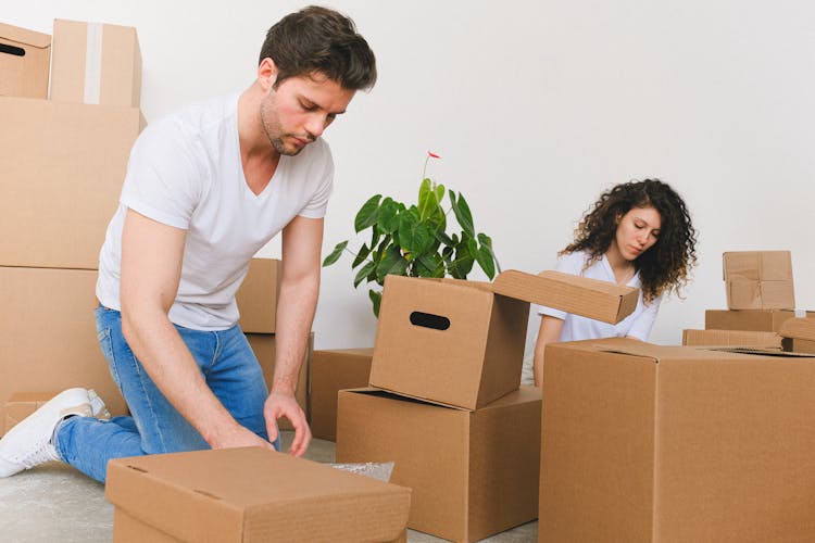 Man And Woman Packing The Boxes