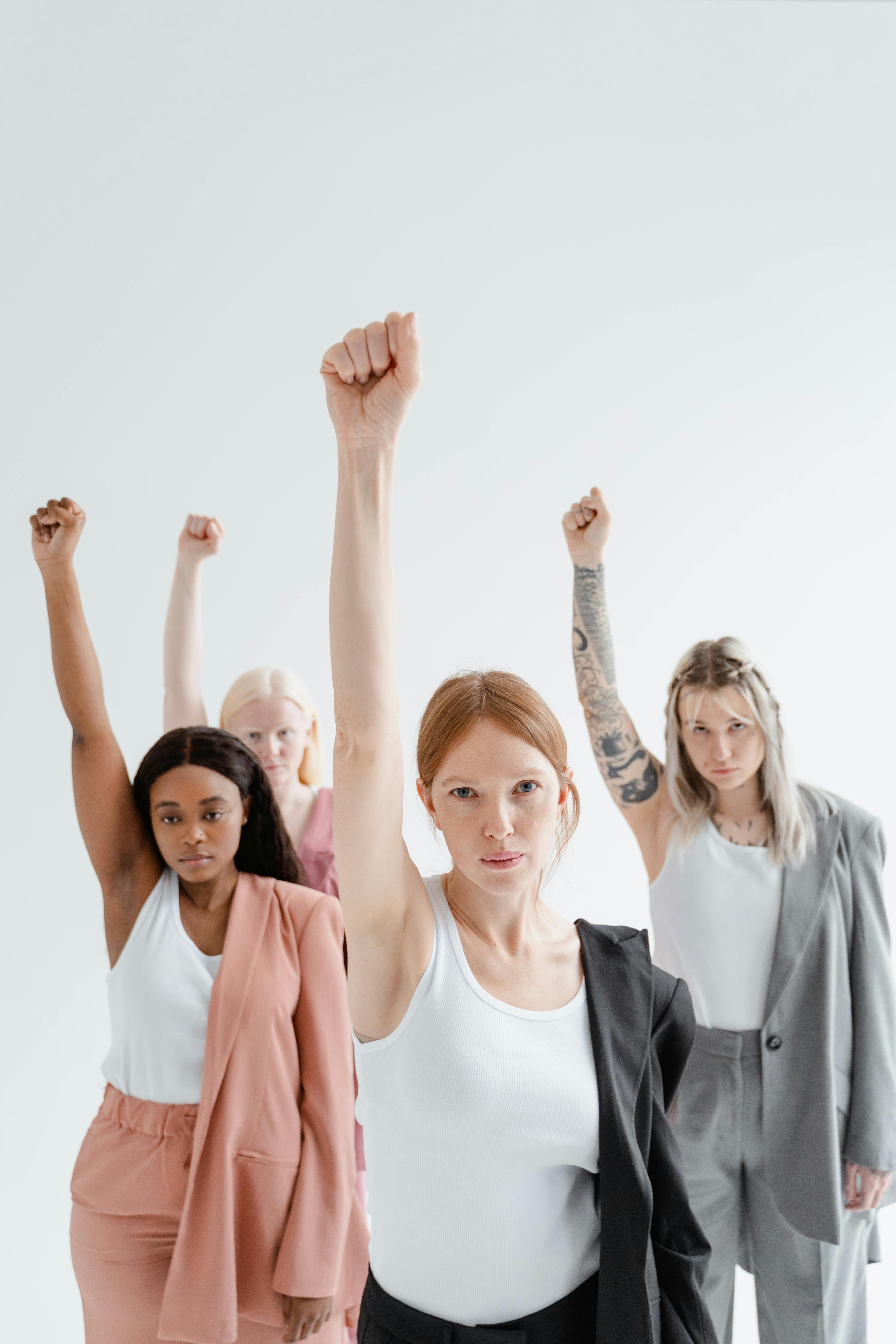 women raising arms and clenching fists