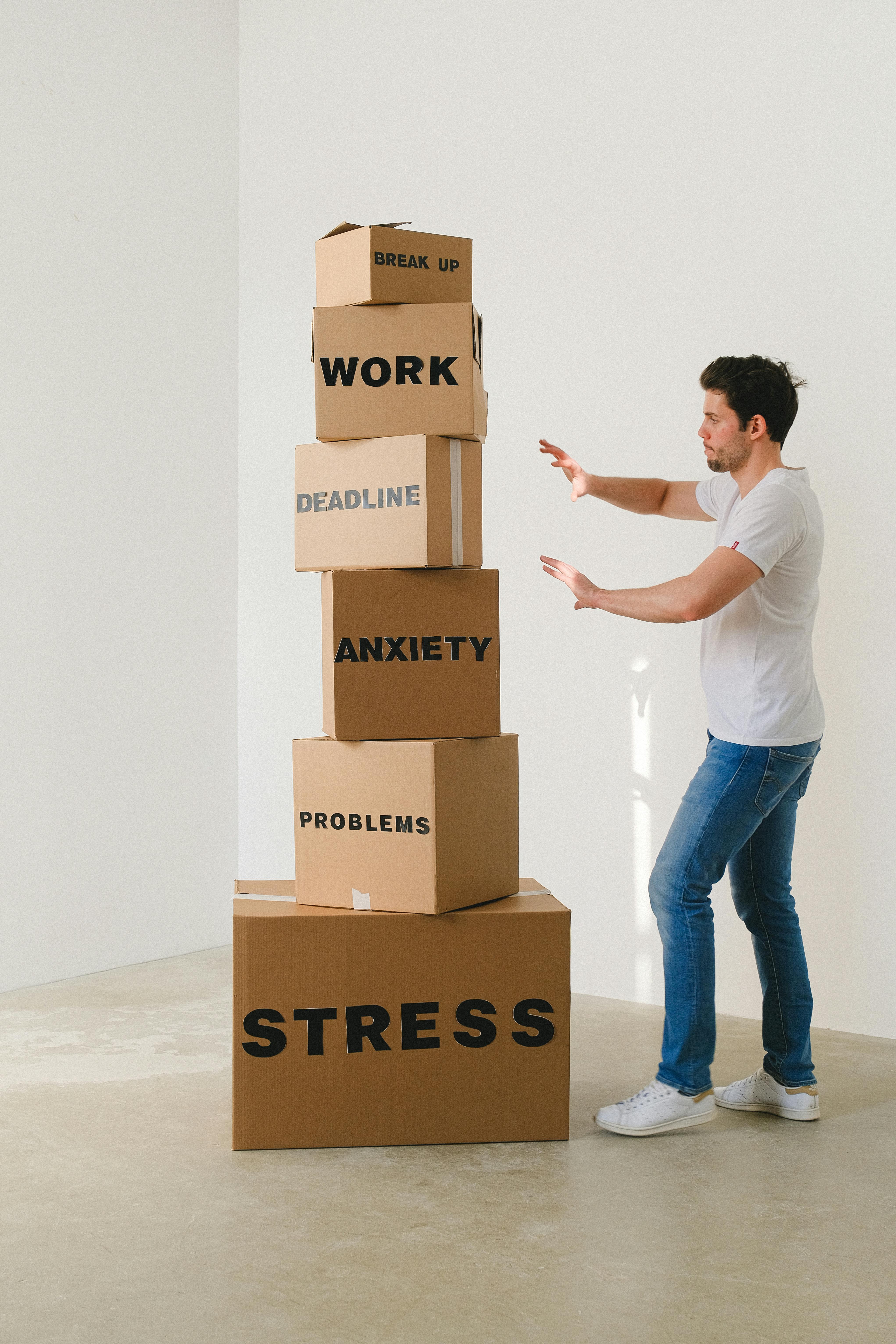 man near carton boxes with many different words about stress