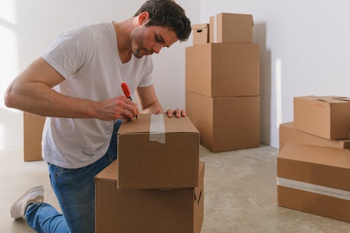 Man Writing Label on Box