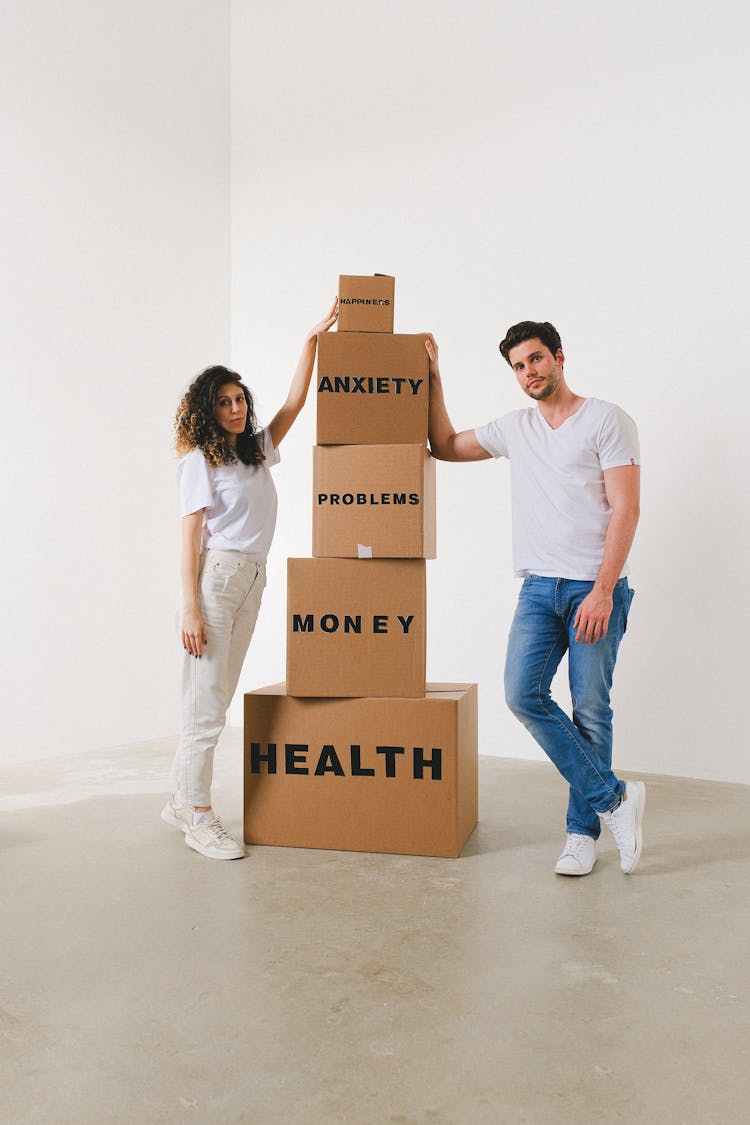 Woman And Man In White Shirt Standing Near Stack Of Boxes