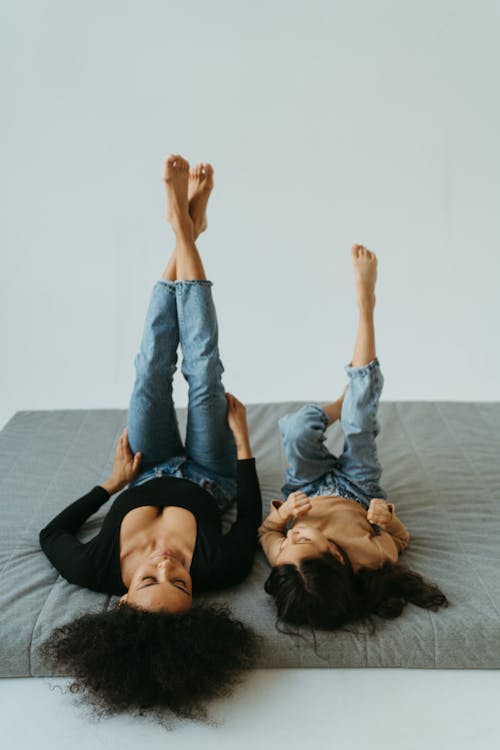 Free Mother and Daughter Lying on the Bed with Legs Up Stock Photo