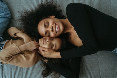 Mom and Daughter Cuddles While Lying Down