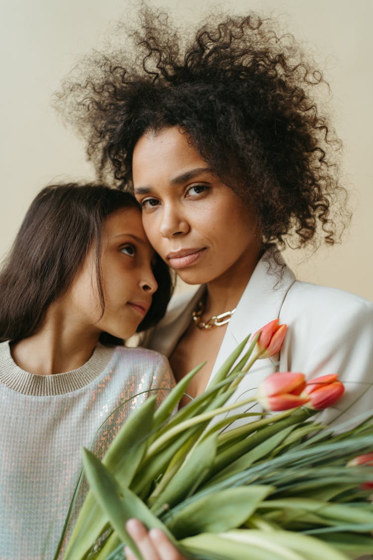 Mother And Daughter Holding Flowers