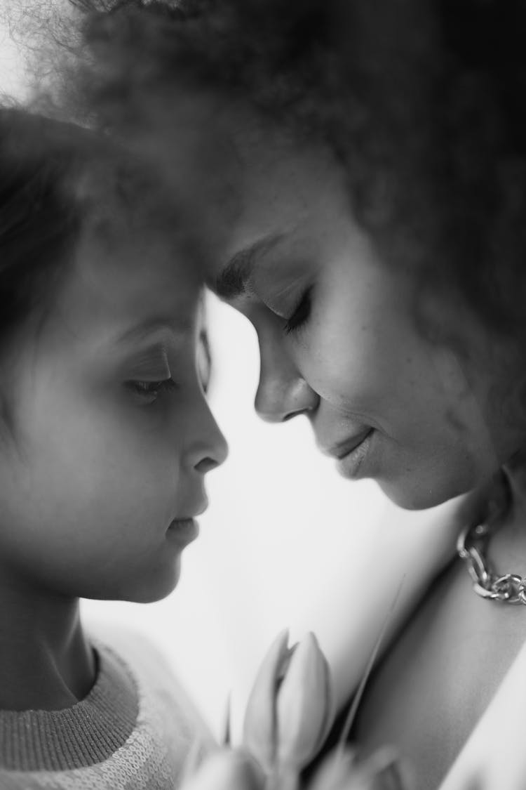 Grayscale Photo Of A Mother And Her Daughter Head To Head