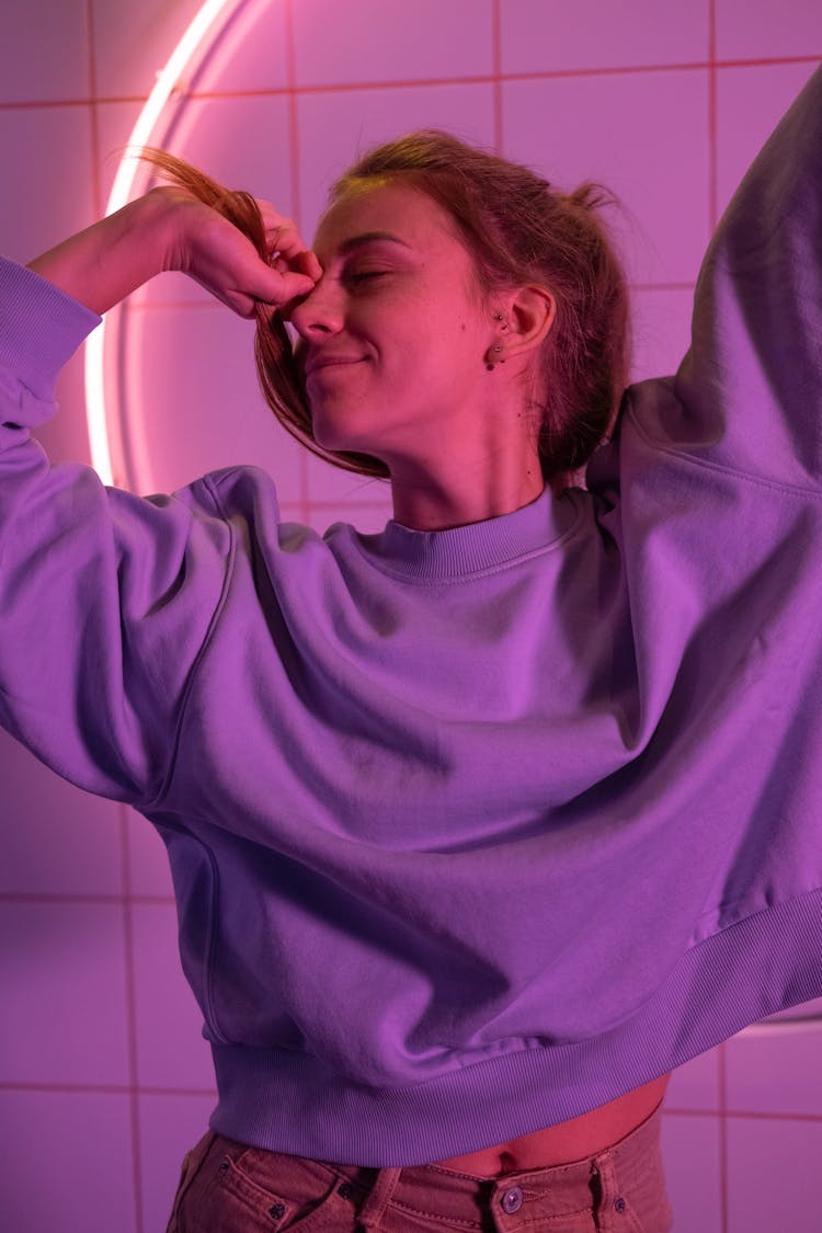 Girl Wearing Sweater Lit By Purple Neon Light