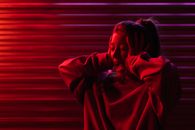 Shouting woman with hands on head in dim red light