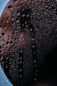 Abstract background of pure water droplets flowing down from glass surface in daytime