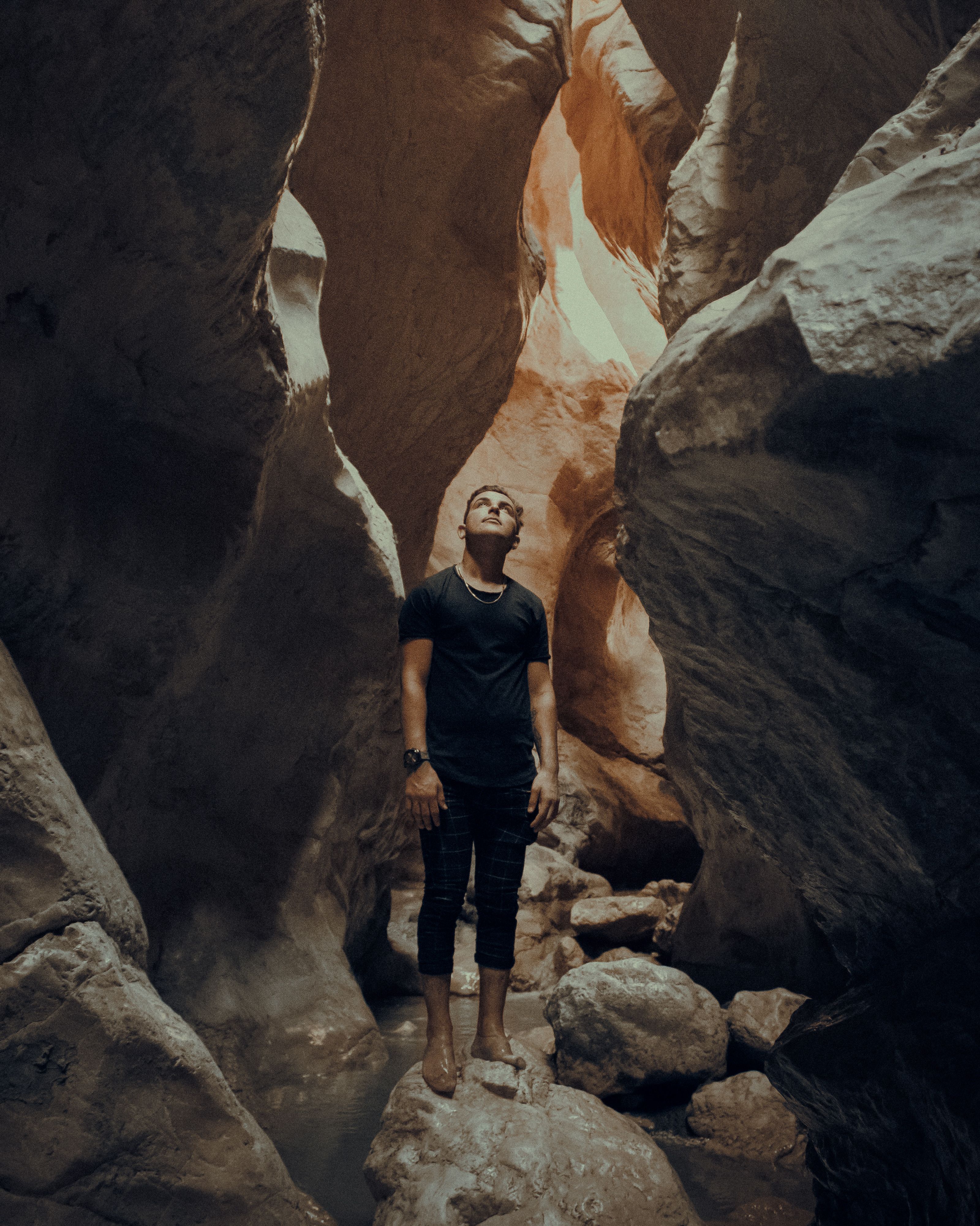 Traveling man standing among rocks · Free Stock Photo