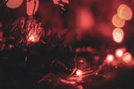 黑暗中，红色圣诞灯的特写镜头营造出温暖的散景效果