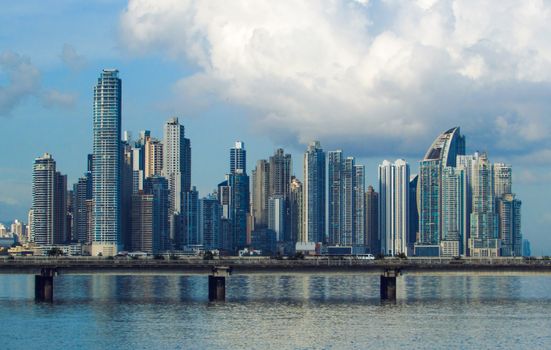 Stunning Panama City skyline featuring modern skyscrapers reflecting in the Pacific Ocean under a blue sky.