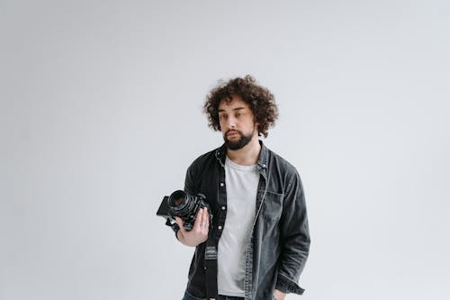 A Photographer with Curly Hair Holding a Camera