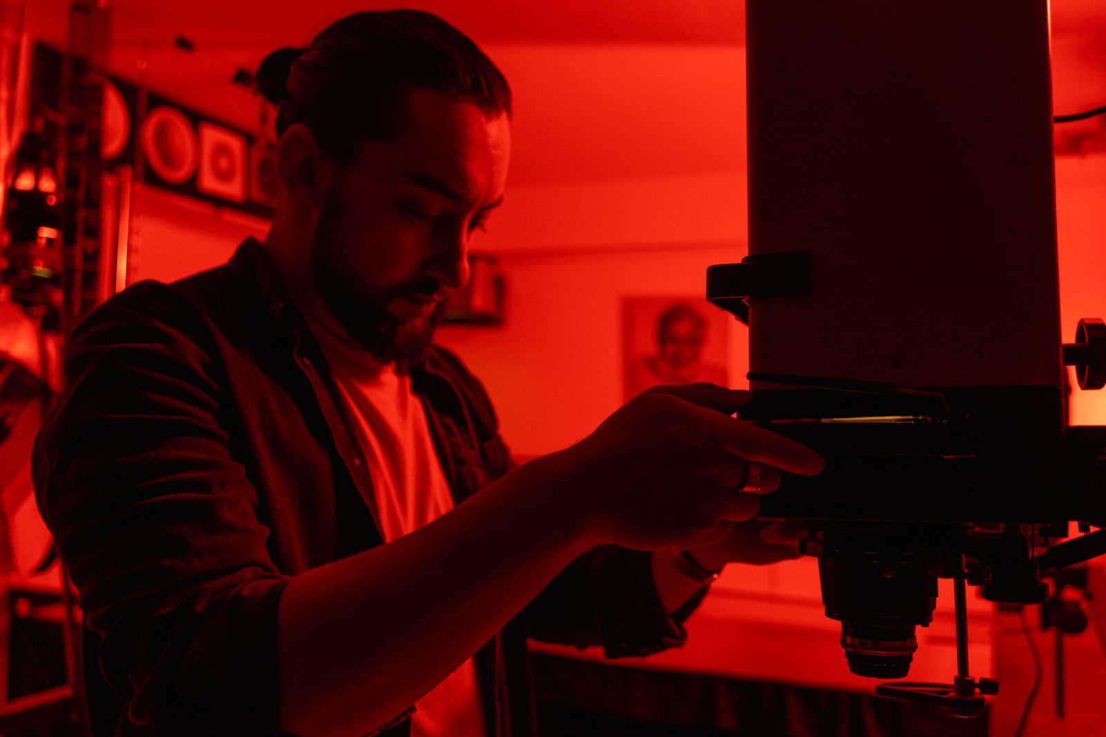Fotógrafo trabajando en un laboratorio de fotografía analógica con una ampliadora