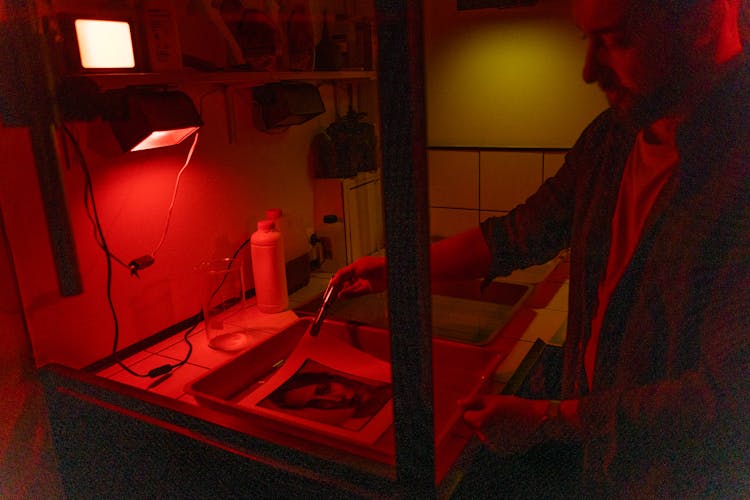 A Photographer Developing A Photo In The Dark Room