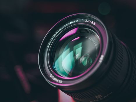 A detailed close-up shot of a camera lens with colorful reflections, showing intricate details.