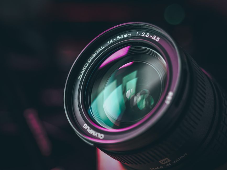 A detailed close-up shot of a camera lens with colorful reflections, showing intricate details.