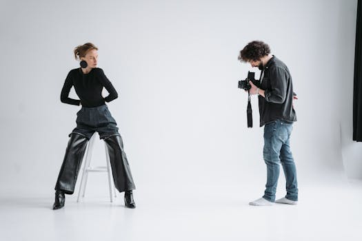 A stylish photoshoot with model and photographer in a bright studio setting.