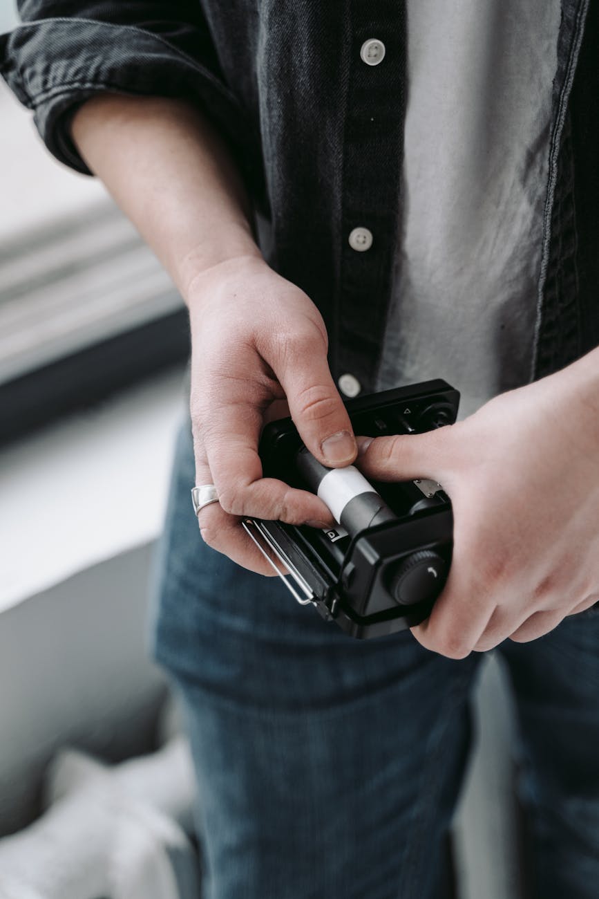 Close-up of hands loading film into a classic vintage camera, highlighting analog photography.