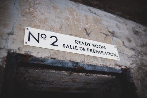 Low angle of new sign above doorway of abandoned building with gray shabby walls with cracks