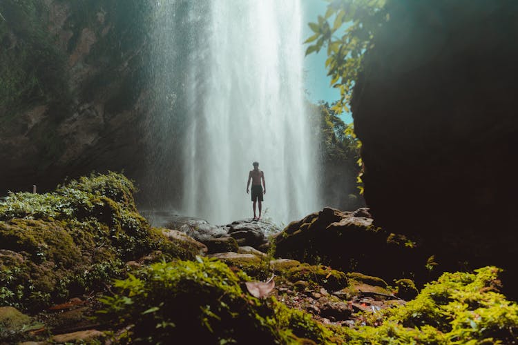 A Man Standing Near A Waterfalls