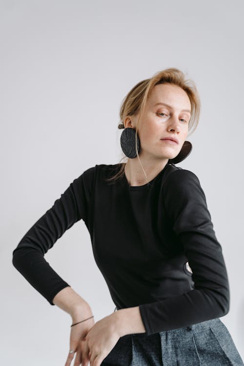 A Woman in Black Long Sleeve Shirt Posing in the Studio