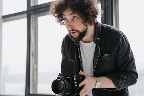 Free A Photographer Using a Black Camera Stock Photo