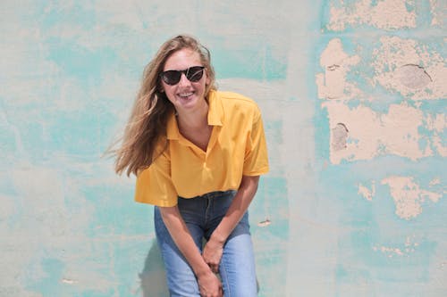 Vrouw Draagt Geel Poloshirt Staande Voor Teal Betonnen Muur