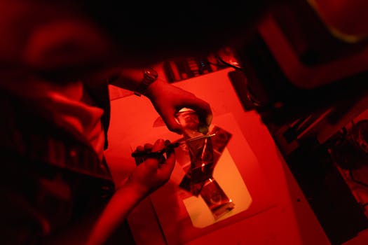 An artistic shot of a photographer's hands working with film negatives in a darkroom.