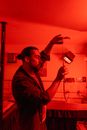 A Man Holding a Strip of Film in the Dark Room