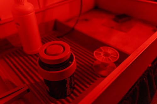 Black and Red Plastic Bottle on Red Table